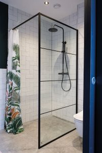 De afscheiding van de douche in de stijl van een taatsdeur houdt de ruimte visueel open