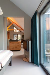 De slaapkamer grenst direct aan de keuken en eetkamer, zodat er vanaf het bed contact is met de andere bewoners