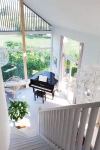 De verticale houten lamellen aan de buitenzijde geven een diffuus lichteffect in de woonkamer