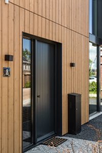 De voordeur heeft dezelfde kleur als het staal in de gevel