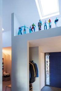 De hal is een vrolijk spel van lijnen, vlakken en licht en een nis als podium voor kleurrijke kunst