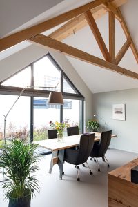 Door de hoogte tot aan de nok is de ruimtebeleving in de zithoek maximaal