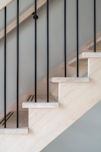 Ondanks de zwarte spijltjes oogt de houten trap lekker licht